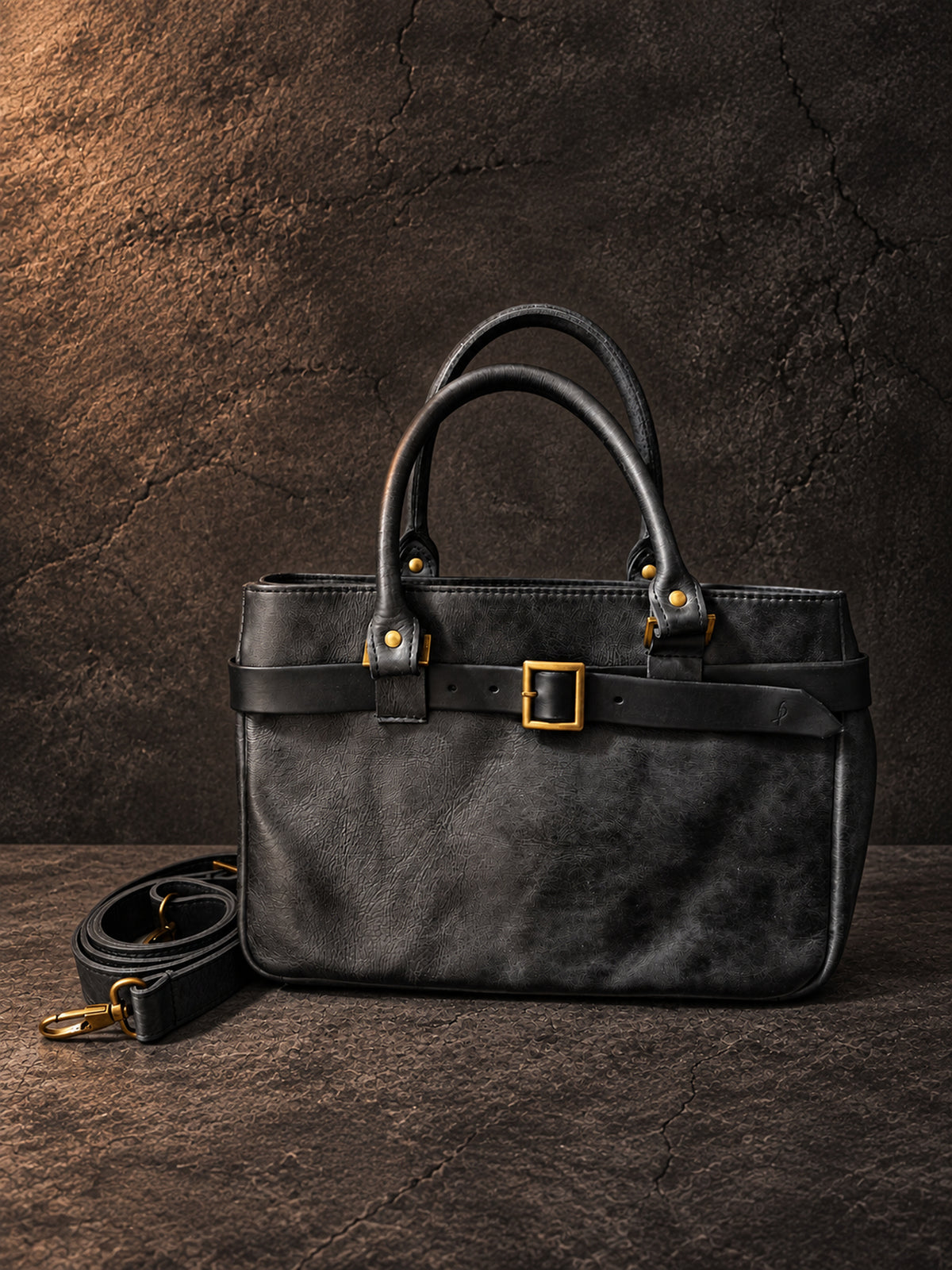 Small black leather handbag front view with long detachable shoulder strap