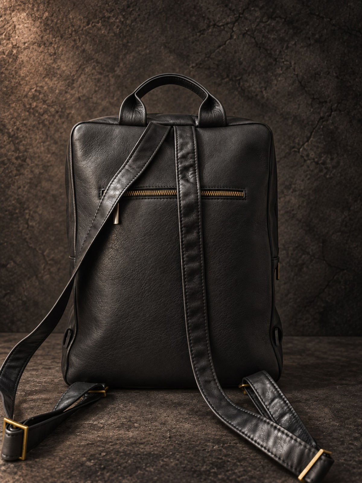 Back view of black leather laptop backpack with shoulder straps