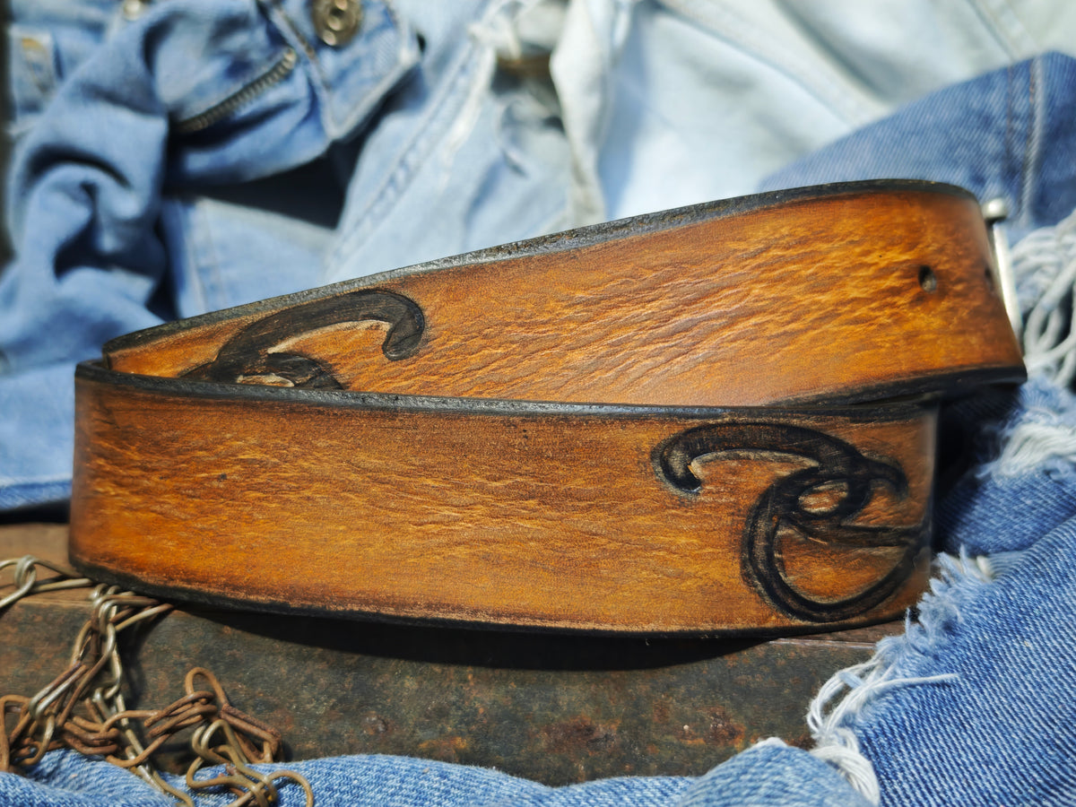 Brown leather belt with a metal buckle embossed with a unique decorative pattern β ISHAOR