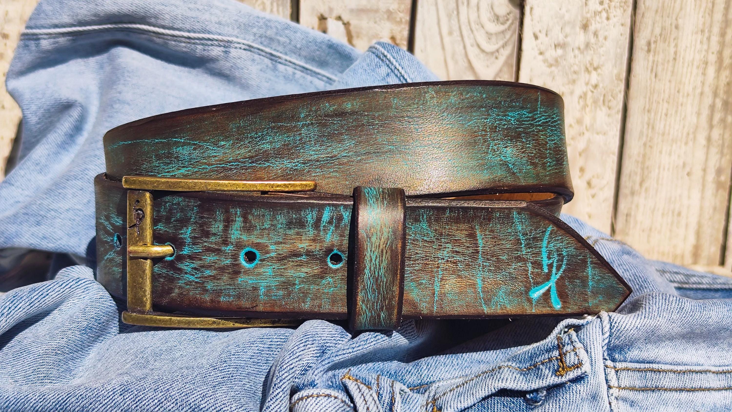Close-up of distressed turquoise leather texture on handmade men's belt.
