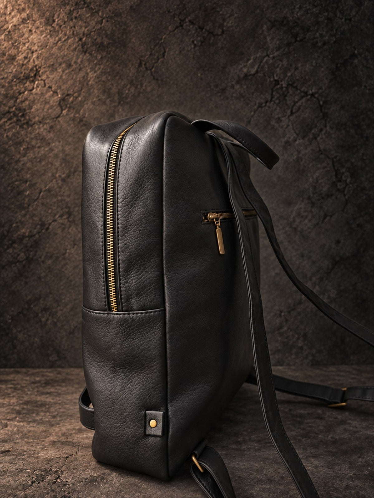 Side view of black leather laptop backpack showing 10 cm depth