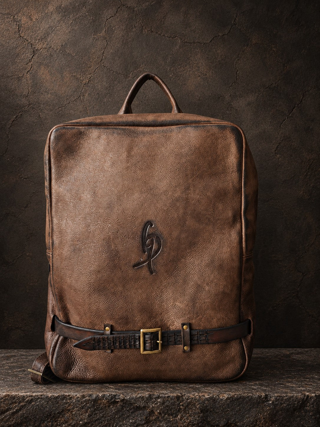 Front view of brown hand-dyed leather backpack with ISHAOR logo pressed into the leather