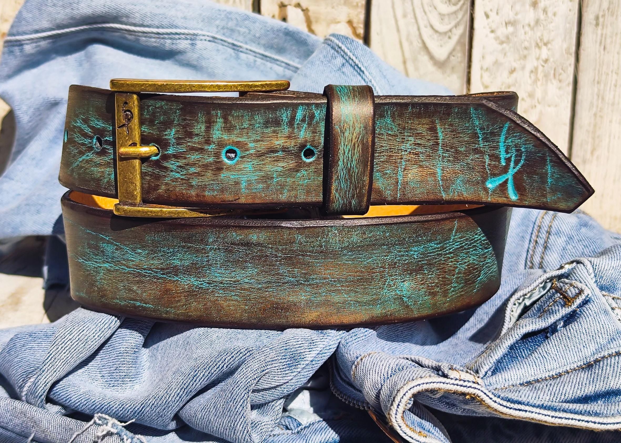 Hand-dyed brown leather belt with turquoise patina effect on denim background