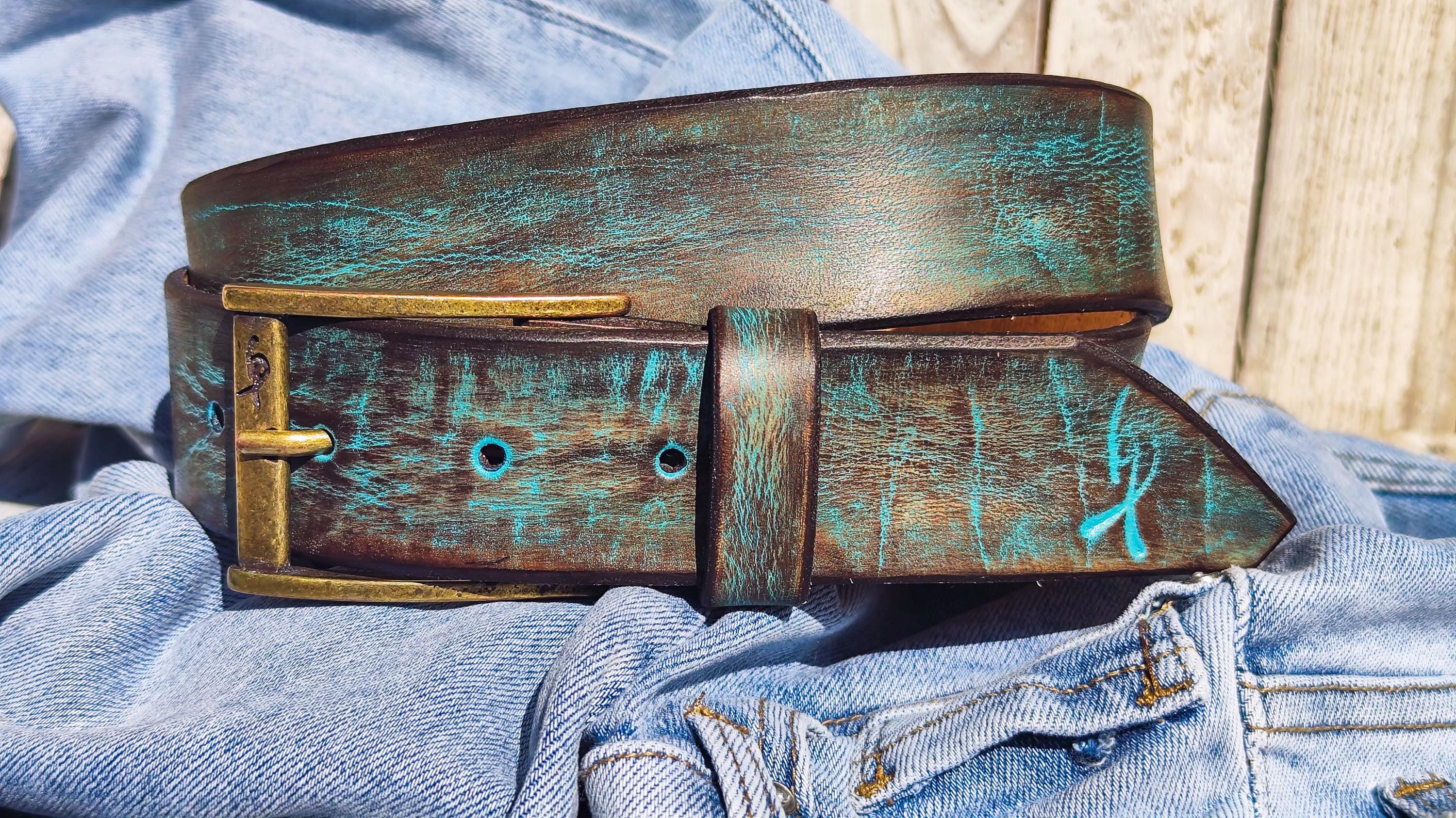 Artistic full-grain leather belt with vintage bronze buckle and teal accents.