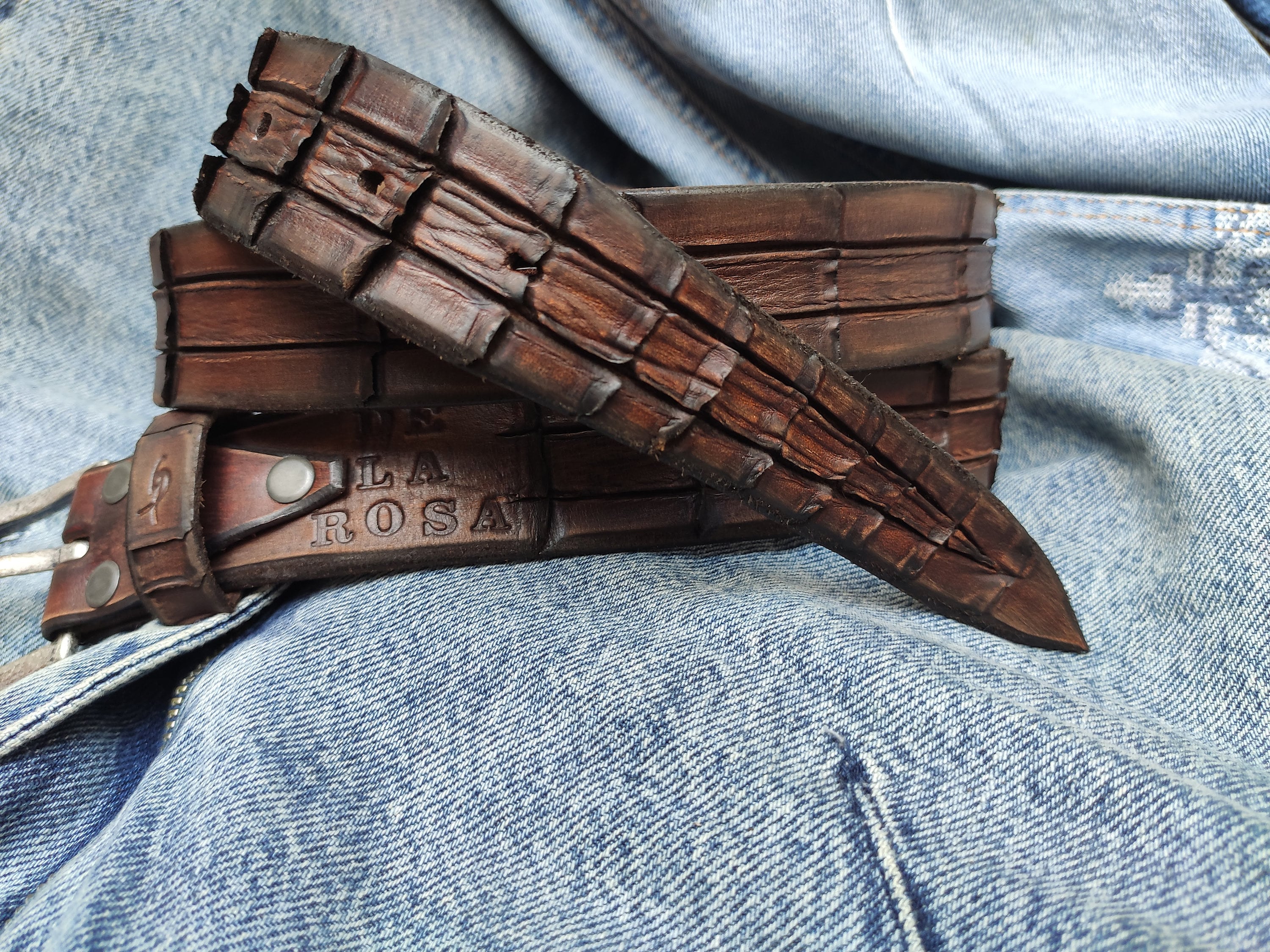 Brown leather belt with handmade cuts in the shape and texture of a crocodile